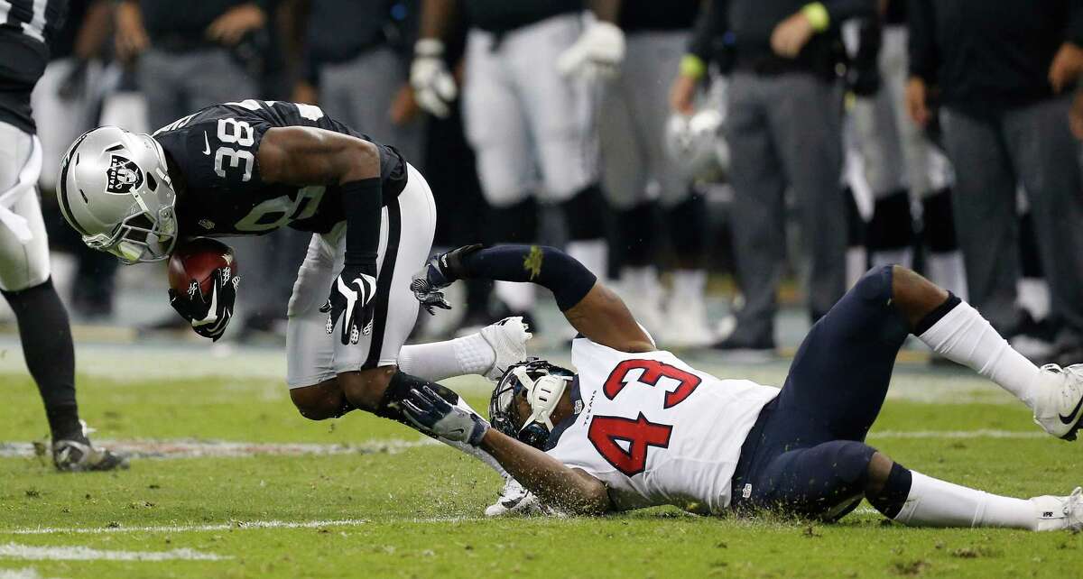 Houston Texans strong safety Corey Moore (43) tries to stop Oakland Raiders T.J. Carrie (38) during the first half of an NFL football game at Estadio Azteca on Monday, Nov. 21, 2016, in Mexico City.
