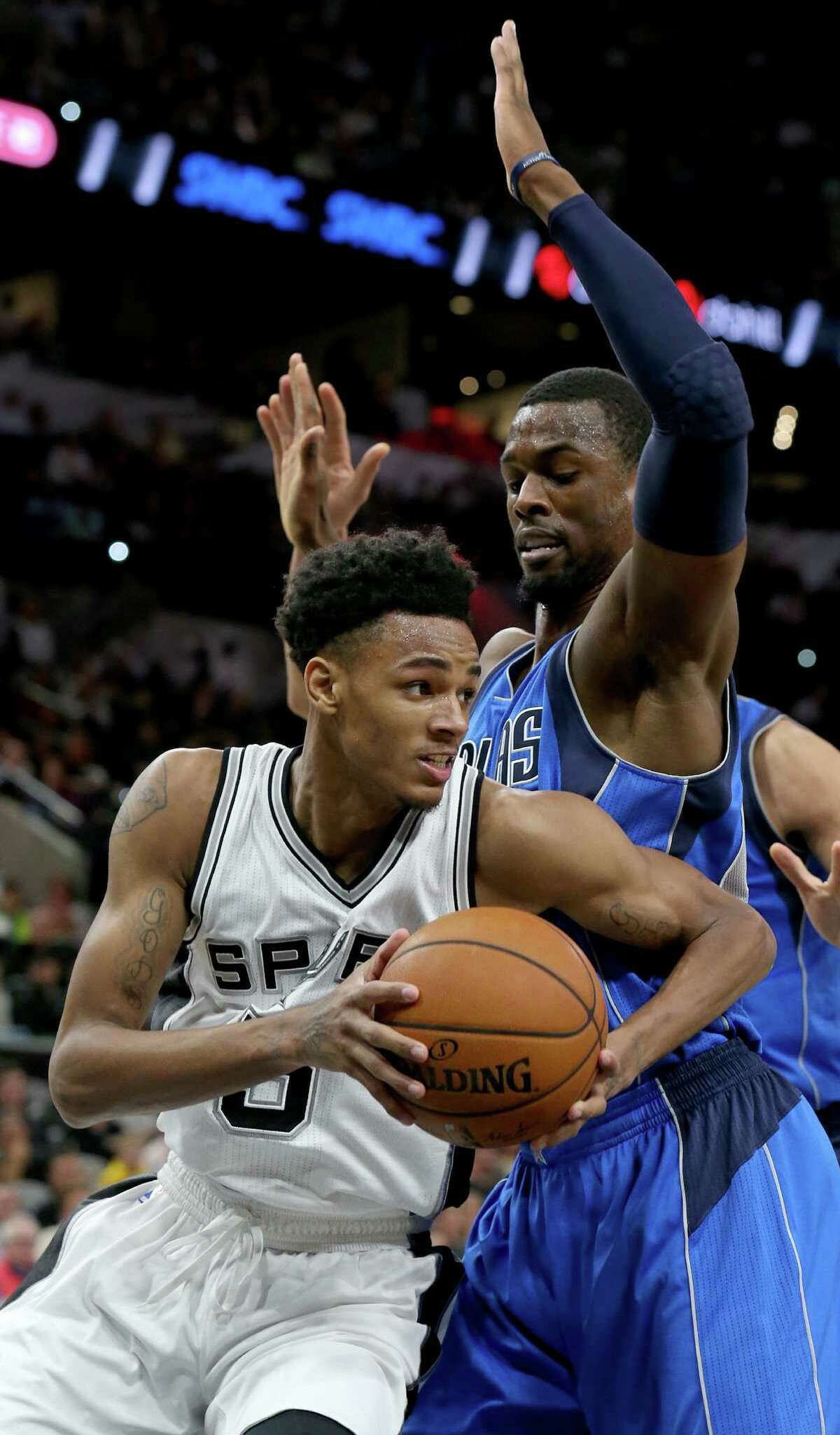 San Antonio Spurs' Dejounte Murray looks for room around Dallas Mavericks' Harrison Barnes during first half action Monday Nov. 21, 2016 at the AT&T Center.