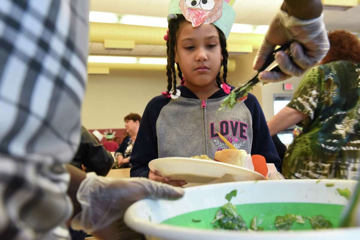 Anastasia Mendez, 6, gets some salad during a Thanksgiving meal in the cafeteria at Delaware Community School on Monday, Nov. 21, 2016 in Albany, N.Y. (Lori Van Buren / Times Union)