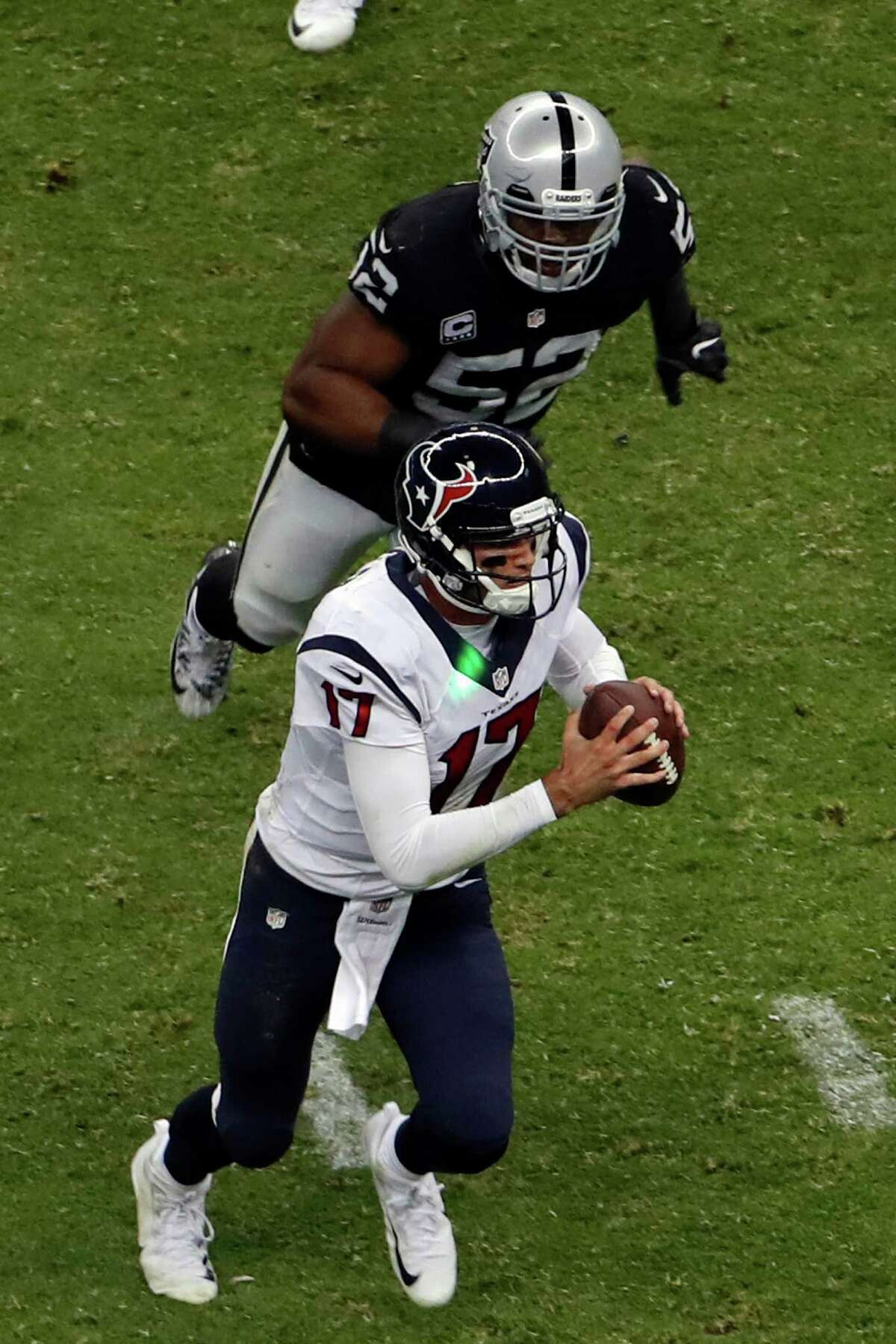 A green laser hits the jersey of Houston Texans quarterback Brock Osweiler as he runs during the second half of an NFL football game against the Oakland Raiders Monday, Nov. 21, 2016, in Mexico City. (AP Photo/Dario Lopez-Mills)