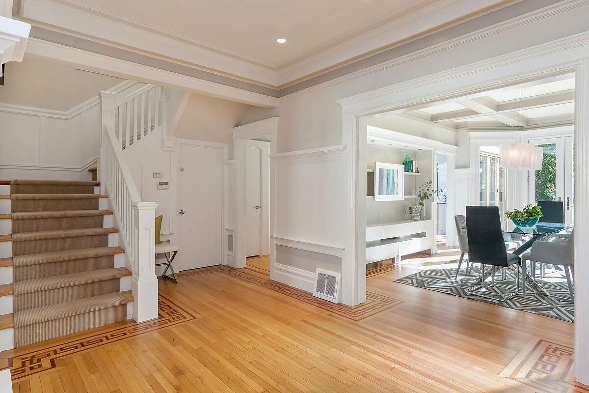 The gracefully appointed foyer includes inlaid hardwood flooring and the turned staircase.