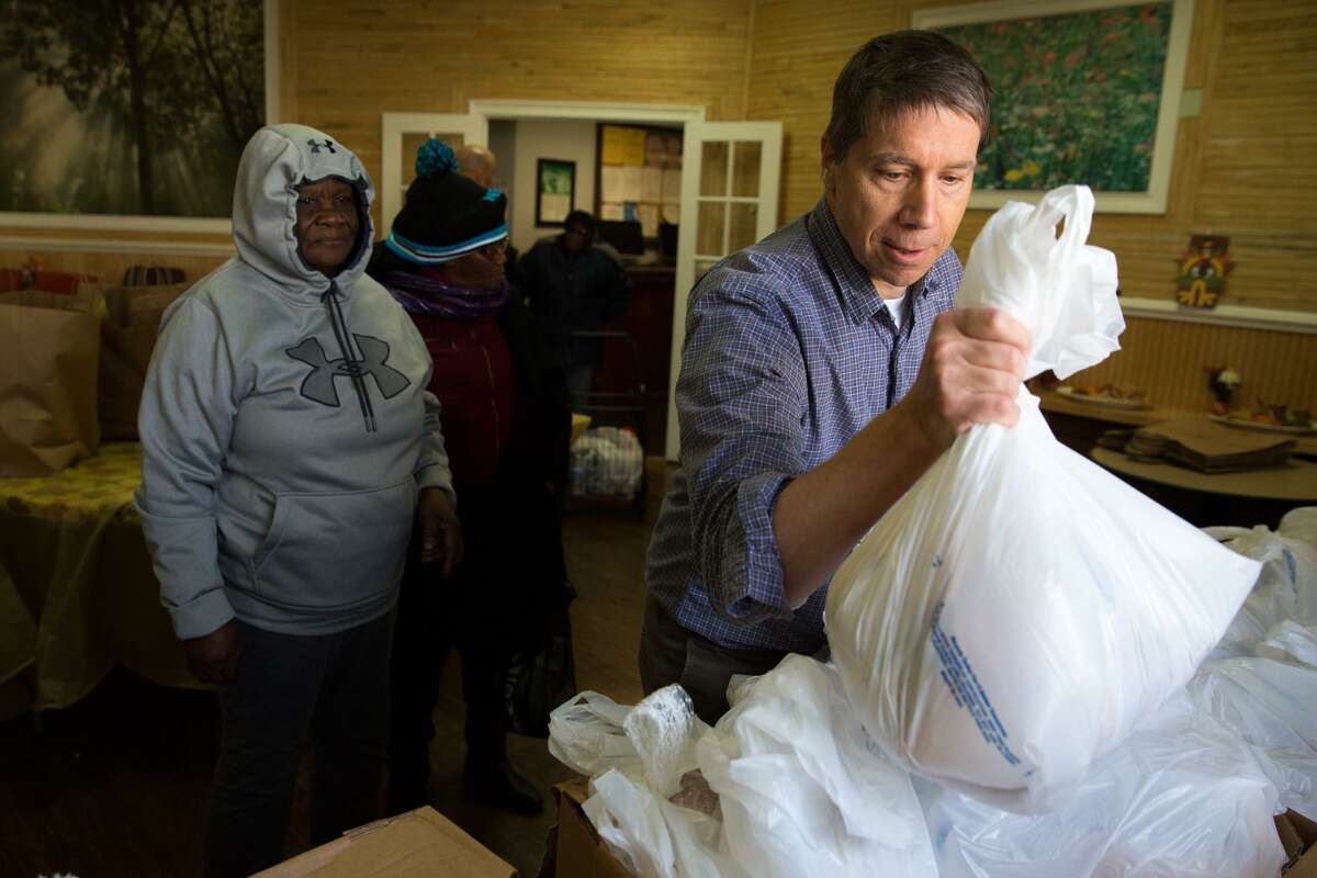 Bill Lattimer, a volunteer from the First Congregational Church in Darien, hands out a turkey at the Open Door Shelter in Norwalk, on Tuesday, Nov. 22. In addition to the 160 turkeys that were donated by Stew Leonard’s for Thanksgiving, recipients also recieved a bag of non-perishable goods.