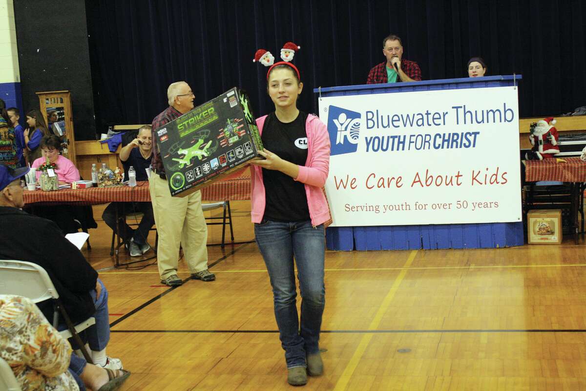 Michaela Dahlke of Harbor Beach shows bidders a glow-in-the–dark drone, which was up for bid during Saturday’s 26th Annual Christmas Benefit Auction for Bluewater Thumb Youth of Christ at the Bad Axe Middle School.