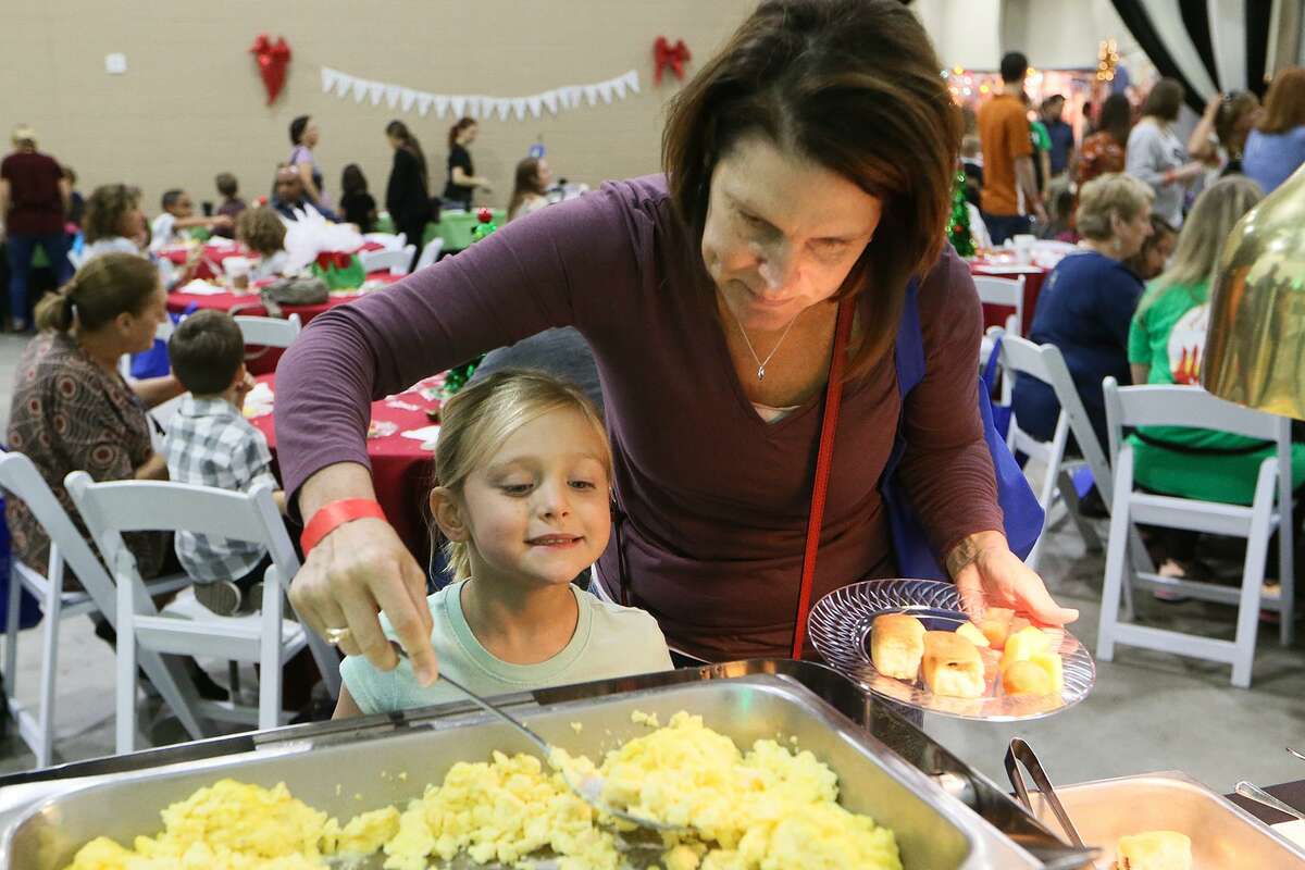 Christine Gard helps her daughter, Sophia Gard, 6, with her plate during a Breakfast with Santa at the Holiday Olé Market, a Junior League of San Antonio fundraiser, at Joe Freeman Coliseum in October. Proceeds from the market benefit the community programs and projects of the Junior League, including Goodwill, Boysville, Children's Shelter, Green Space Alliance, Arc of SA and many more.