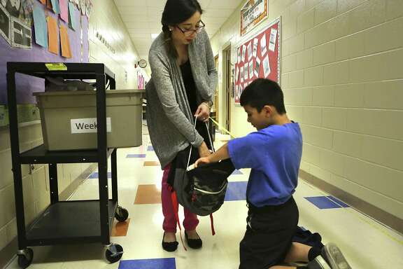 Marizol Cortez, Counselor Clerk at James Madison Elementary School, hands out a bag of food to Richard Perez, 10 years old, a forth grader at the school, on Thursday, Nov. 3, 2016. Perez is a student participant in Snack Pak 4 Kids in San Antonio.