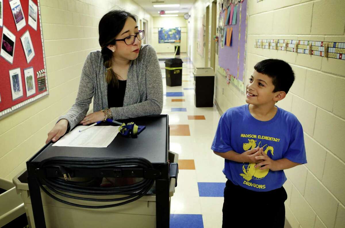 Marizol Cortez (left), counselor clerk at James Madison Elementary School, walks with fourth grader Richard Perez, a student participant in Snack Pak 4 Kids in San Antonio.