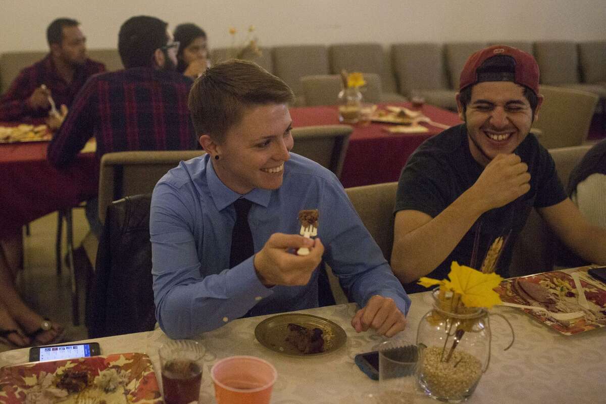 Erin Marquise (left) and Joey Sanchez laugh over dinner during the 10th annual Gay Thanksgiving event at Living Church at Woodlawn Pointe in San Antonio on Nov. 12.