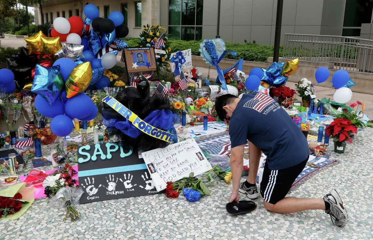 Jeffrey Saenz placed some flowers at make-shift memorial at the San Antonio Police Headquarters for slain police officer Marconi on Tuesday, November 22, 2016.