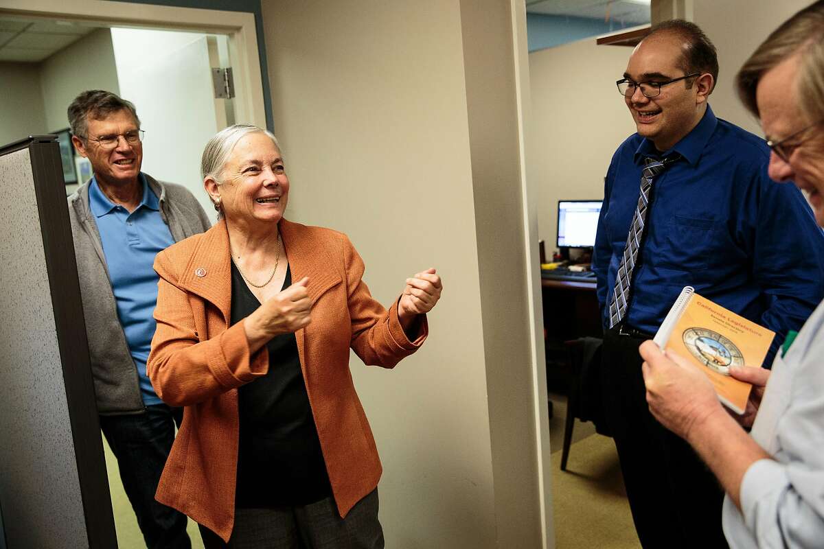 California State Senator Fran Pavley, D-Agoura Hills, center, jokes with aide Chris Chavez, right, as her husband Andy Pavley, left, looks on in her office at the State Capitol in Sacramento, California, November 2, 2016.
