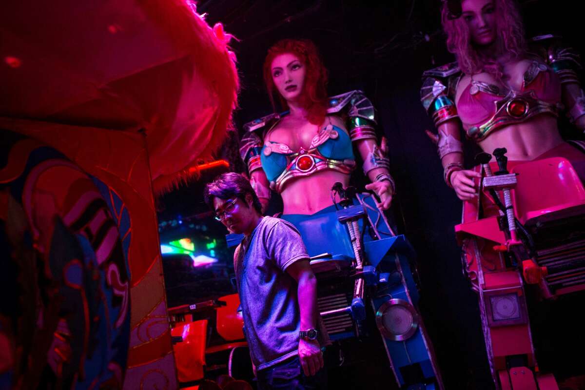 TOKYO, JAPAN - JUNE 29: A staff member works to prepare two large female robots prior to the start of a show at The Robot Restaurant on June 29, 2014 in Tokyo, Japan. The now famous Robot Restaurant opened two years ago in Kabukicho area of Shinjuku at an estimated cost of 10 million U.S. dollars. Performances are held three times a day and cater mostly to foreign tourists. The cabaret style shows include bikini clad futuristic dancers, performers dressed as robots and a host of large scale robots and vehicles controlled with remotes by stage hands dressed as Ninjas (Photo by Chris McGrath/Getty Images)