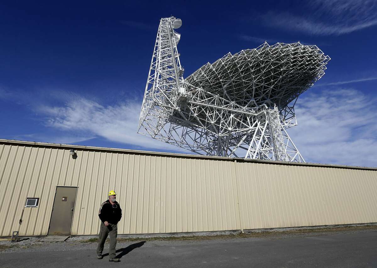 In this Nov. 14, 2013 photo, Michael Holstine, business manager at the National Radio Astronomy Observatory, walks out of a shed underneath the Robert C. Byrd Green Bank Telescope in Green Bank, W.Va. Standing taller than the Statue of Liberty, it's the largest fully-steerable radio telescope in the world. It's also incredibly sensitive -- so sensitive that it is able to detect energy in outer space that is equivalent to the energy emitted by a single snowflake hitting the ground. The quiet zone allows scientists to hear these faint signals that would otherwise be obscured by man-made interference. (AP Photo/Patrick Semansky)