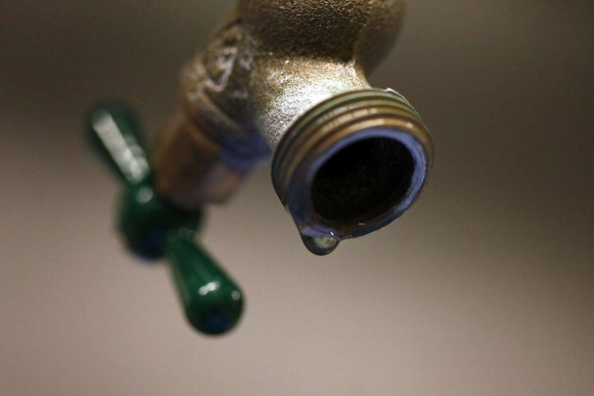 A drip sits on the edge of the faucet.