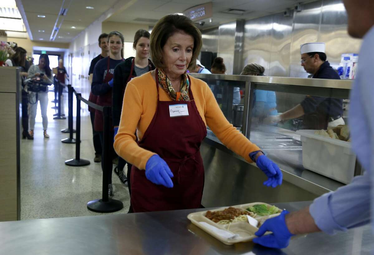 Rep. Nancy Pelosi delivers a lunch plate of pasta fagioli to guests at the St. Anthony's Foundation dining room in San Francisco, Calif. on Wednesday, Nov. 23, 2016. Volunteering during the holiday season is an annual activity for Pelosi.