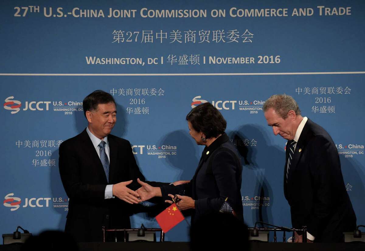 Commerce Secretary Penny Pritzker, center, shakes hands with Chinese Vice Premier of the State Council Wang Yang, left, with U.S. Trade Representative Ambassador Michael Froman at right, during a signing ceremony at the 27th session of the U.S.-China Joint Commission on Commerce and Trade in Washington, Wednesday, Nov. 23, 2016. (AP Photo/Susan Walsh)
