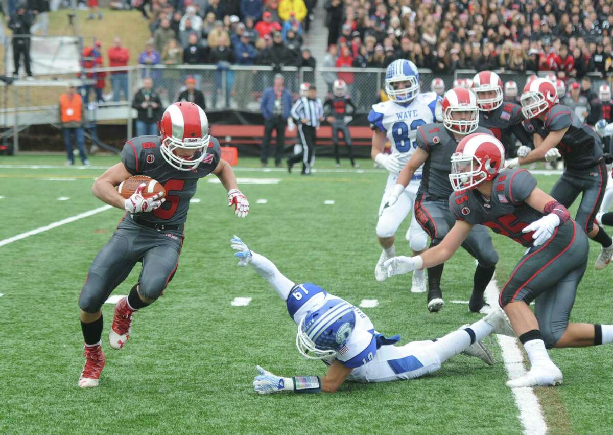 New Canaan's Jackson Appelt (6) avoids a tackle from Darien's Patrick Burke (19) in Darien's 37-34 win over New Canaan in the Turkey Bowl high school football game at Dunning Stadium in New Canaan, Conn. Thursday, Nov. 24, 2016. New Canaan scored 24 unanswered points to tie the game and force an overtime. In overtime, Darien kicked a field goal to take the lead and forced a New Canaan interception to end the game, setting off a wild celebration as fans stormed the field.