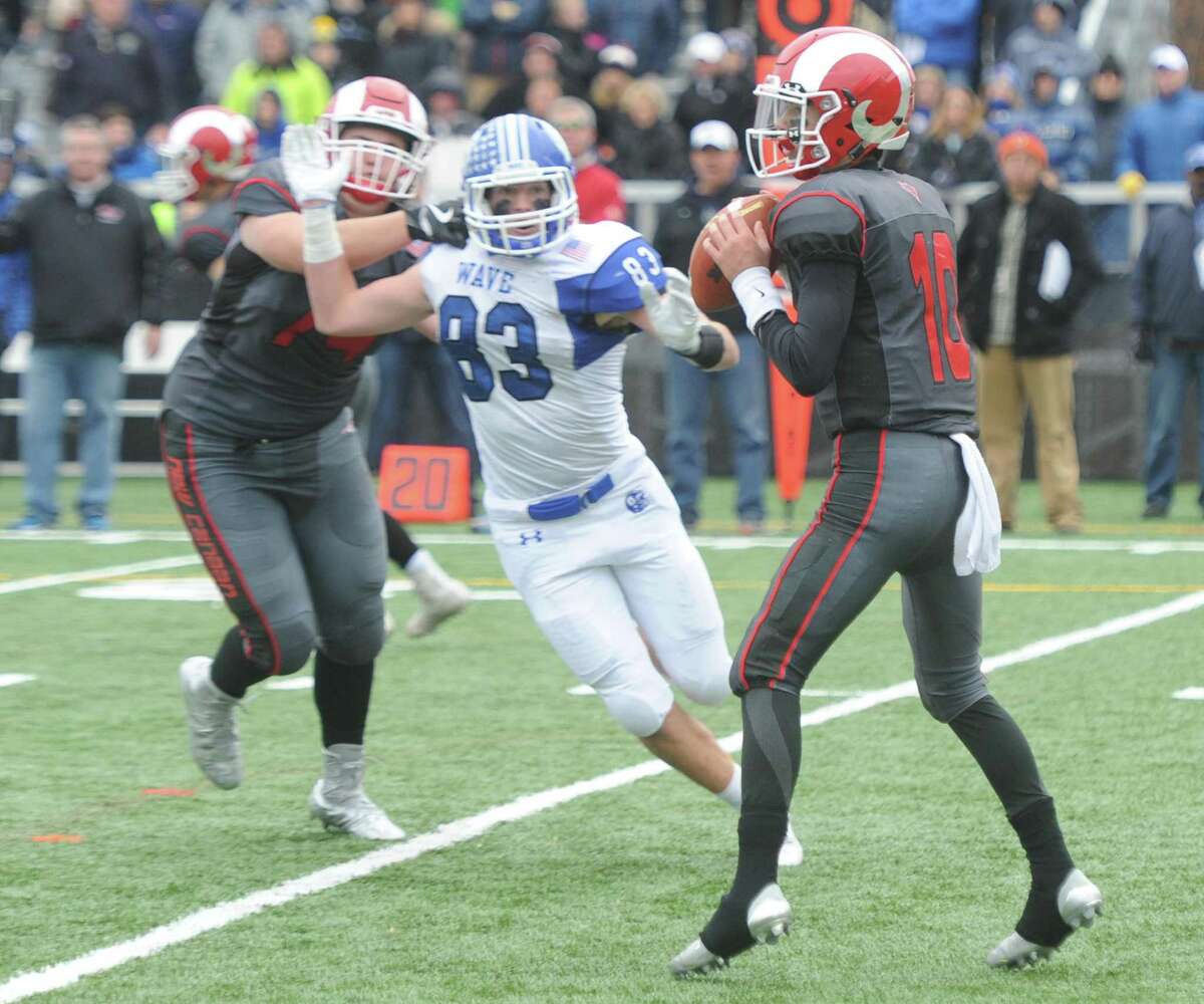 New Canaan quarterback Drew Pyne (10) looks to throw as Darien's Quinlin Fay (83) charges in to cause a fumble, which would be returned for a touchdown in Darien's 37-34 win over New Canaan in the Turkey Bowl high school football game at Dunning Stadium in New Canaan, Conn. Thursday, Nov. 24, 2016. New Canaan scored 24 unanswered points to tie the game and force an overtime. In overtime, Darien kicked a field goal to take the lead and forced a New Canaan interception to end the game, setting off a wild celebration as fans stormed the field.
