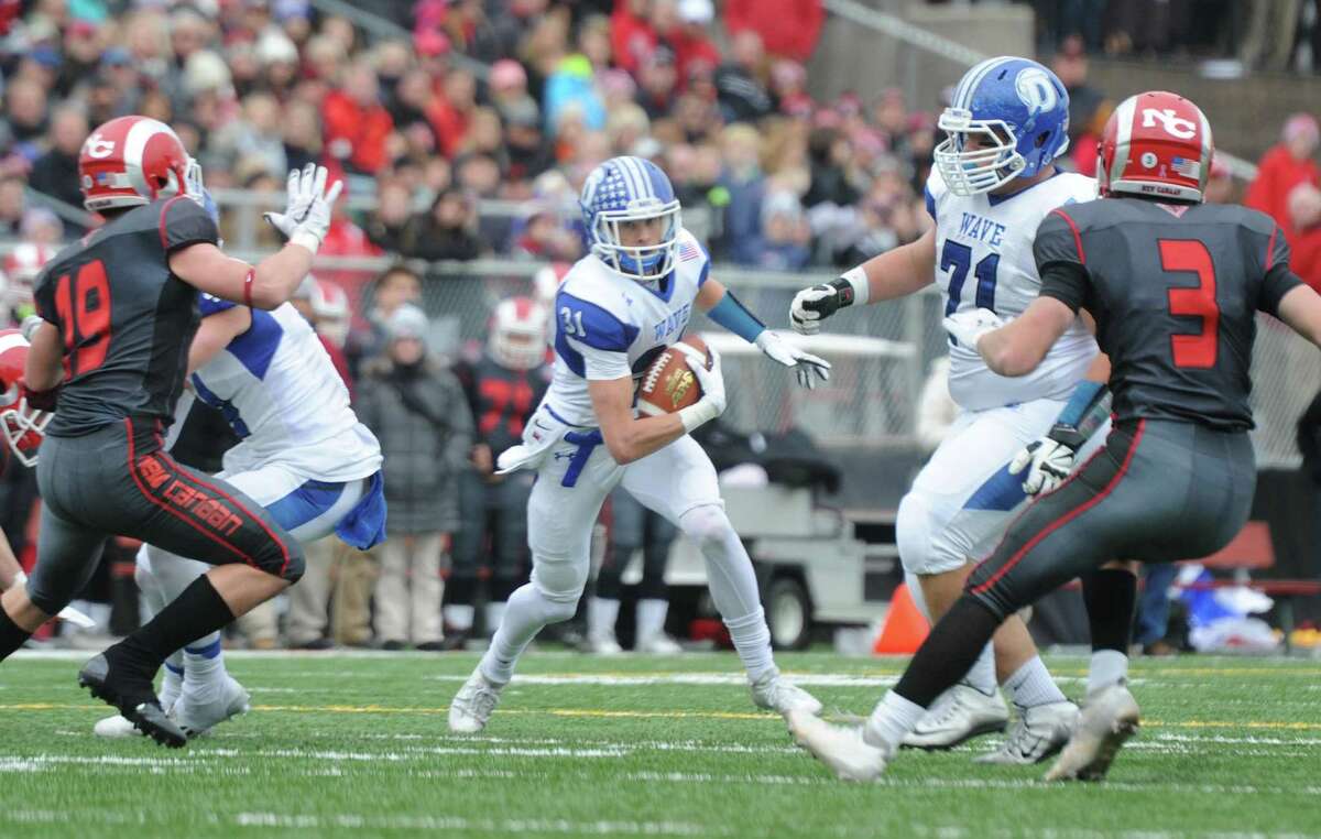 Photos from Darien's 37-34 win over New Canaan in the Turkey Bowl high school football game at Dunning Stadium in New Canaan, Conn. Thursday, Nov. 24, 2016. New Canaan scored 24 unanswered points to tie the game and force an overtime. In overtime, Darien kicked a field goal to take the lead and forced a New Canaan interception to end the game, setting off a wild celebration as fans stormed the field.