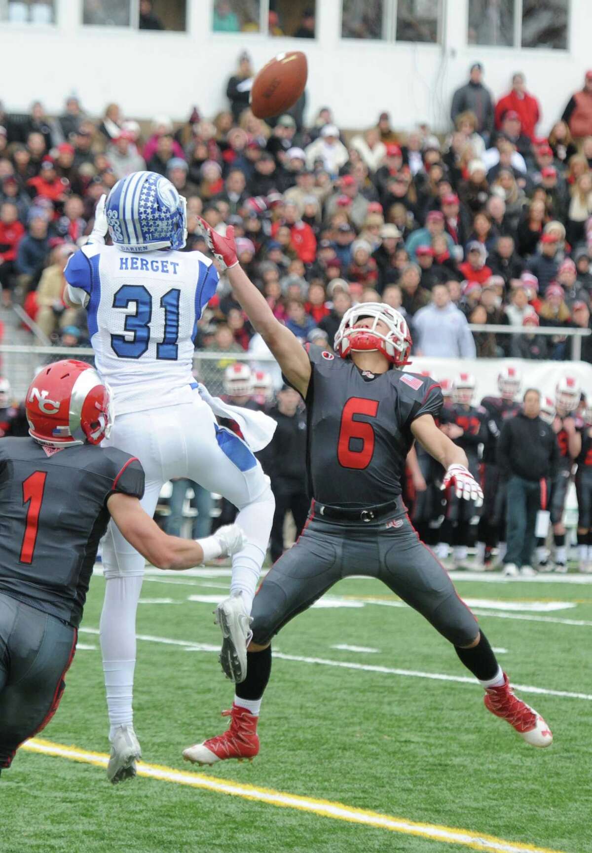 Photos from Darien's 37-34 win over New Canaan in the Turkey Bowl high school football game at Dunning Stadium in New Canaan, Conn. Thursday, Nov. 24, 2016. New Canaan scored 24 unanswered points to tie the game and force an overtime. In overtime, Darien kicked a field goal to take the lead and forced a New Canaan interception to end the game, setting off a wild celebration as fans stormed the field.