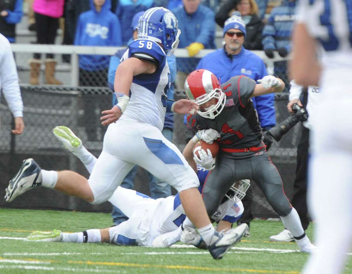 Photos from Darien's 37-34 win over New Canaan in the Turkey Bowl high school football game at Dunning Stadium in New Canaan, Conn. Thursday, Nov. 24, 2016. New Canaan scored 24 unanswered points to tie the game and force an overtime. In overtime, Darien kicked a field goal to take the lead and forced a New Canaan interception to end the game, setting off a wild celebration as fans stormed the field.