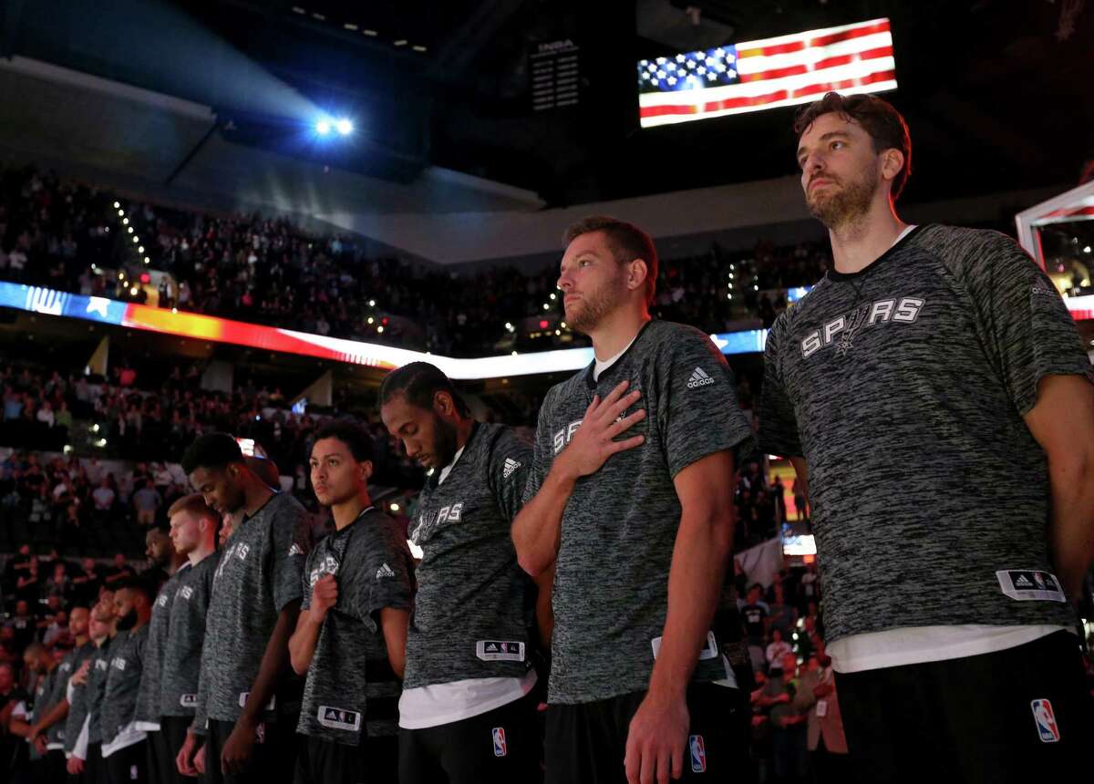 Spurs’ Pau Gasol (from right), David Lee, Kawhi Leonard, Bryn Forbes, and others stand during the national anthem before their preseason game with the Houston Rockets on Oct. 21, 2016 at the AT&T Center.