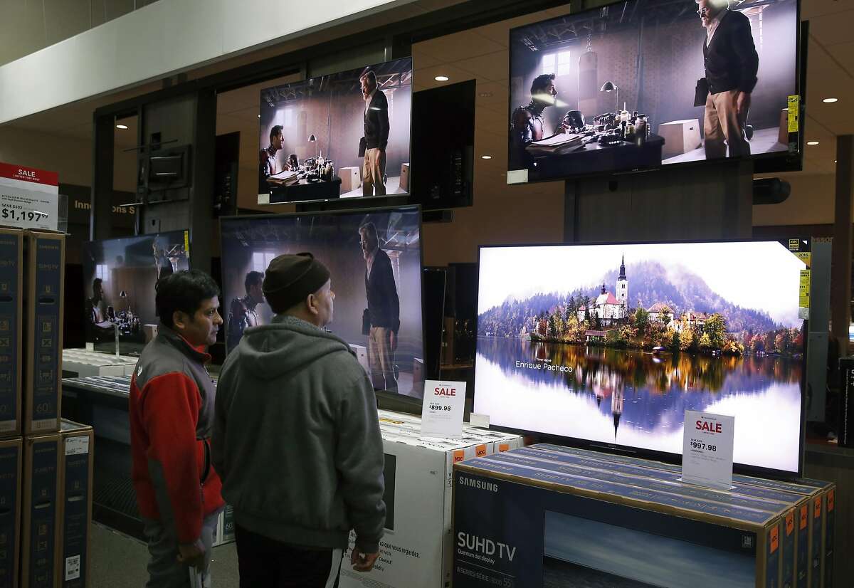 Black Friday shoppers pause to look at flatscreen televisions on sale at the Best Buy in Emeryville, Calif. on Friday, Nov. 25, 2016.