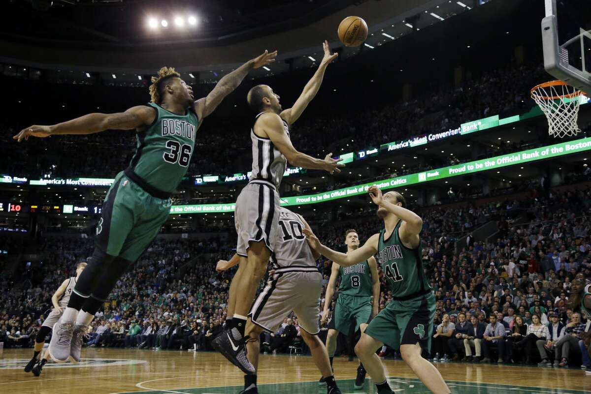 San Antonio Spurs guard Manu Ginobili gets a shot off between Boston Celtics guard Marcus Smart (36) and center Kelly Olynyk (41) in the first half of an NBA basketball game, Friday, Nov. 25, 2016, in Boston. (AP Photo/Elise Amendola)