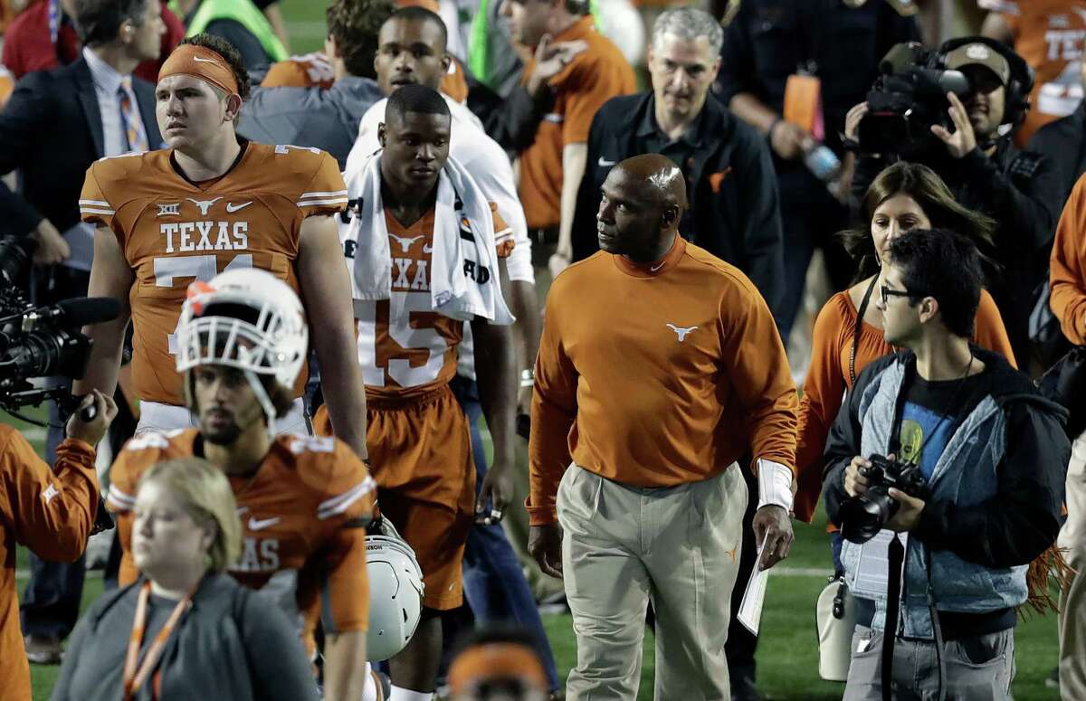 Texas coach Charlie Strong, right, looks to the stands as he walks off the field with his team after Friday's loss to TCU in Austin.