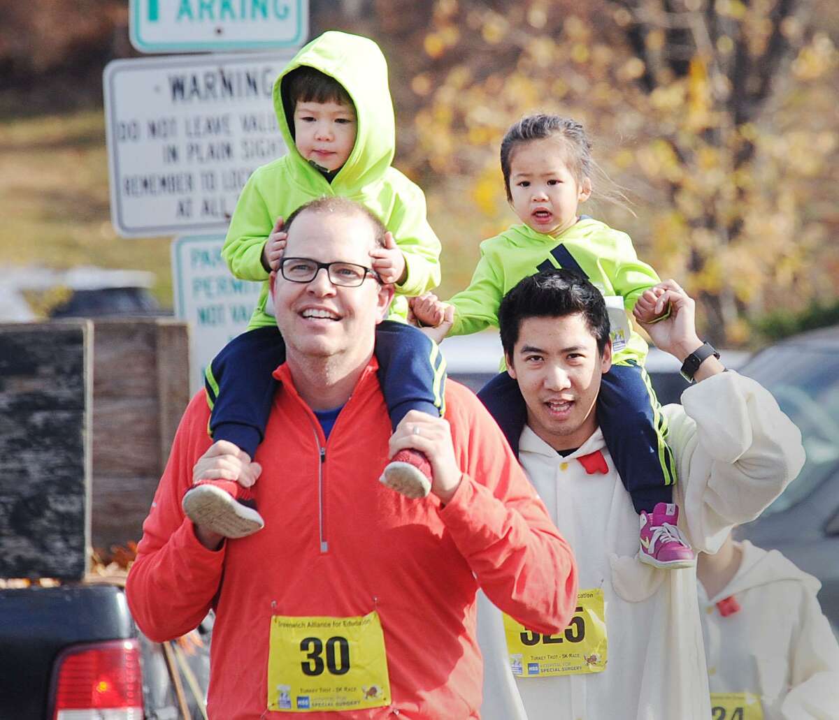 At right, Greenwich resident Jon Liu (325) might have come in last during the 1-mile fun run and walk but that was only because, like others, he carried his child, Josslyn, 2, on his shoulders for most of the race during the Greenwich Alliance for Education's annual Turkey Trot starting at the Arch Street Teen Center in Greenwich, Conn., Saturday morning, Nov.26, 2016. Race official Mickey Yardis said over1,000 runners participated in the fund-raising benefit race. All proceeds from the race go to foster the Alliance's educational success programs for the Greenwich Public Schools.