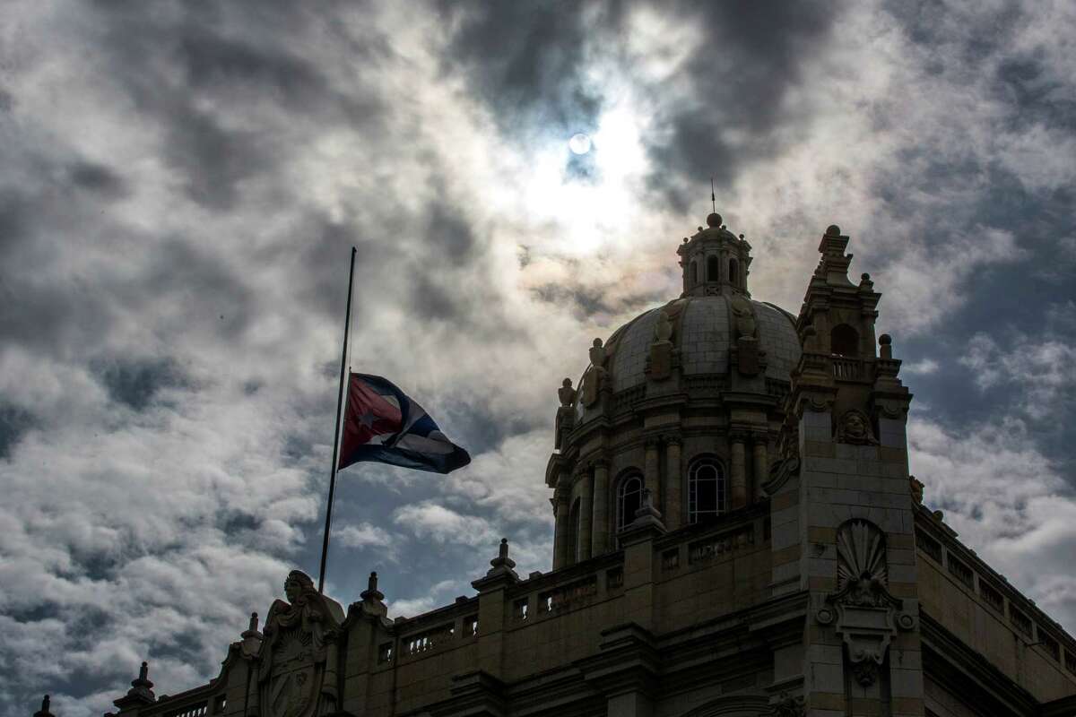 The Cuban flag flies at half-mast outside the Museum of the Revolution, formerly the presidential palace, in Havana, Cuba, Saturday, Nov. 26, 2016, one day after Fidel Castro's death. Cuba will observe nine days of mourning for the former president who ruled Cuba for half a century. (AP Photo/Desmond Boylan)