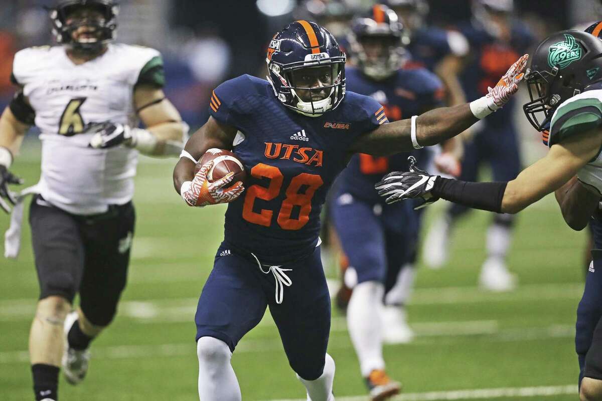 Roadrunner running back Jalen Rhodes stiff arms a tackler after a long gain in the second quarter as UTSA hosts Charlotte at the Alamodome on November 26, 2016.