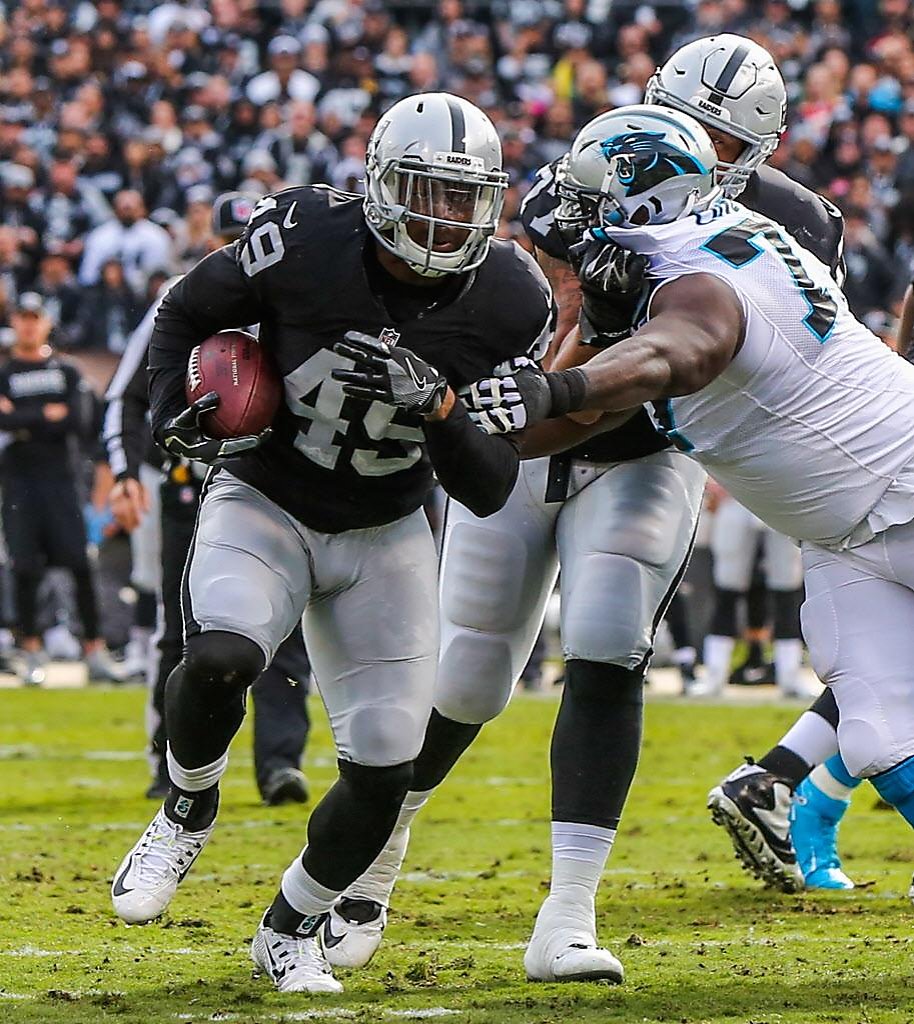 Oakland Raiders fullback Jamize Olawale powers through the line to