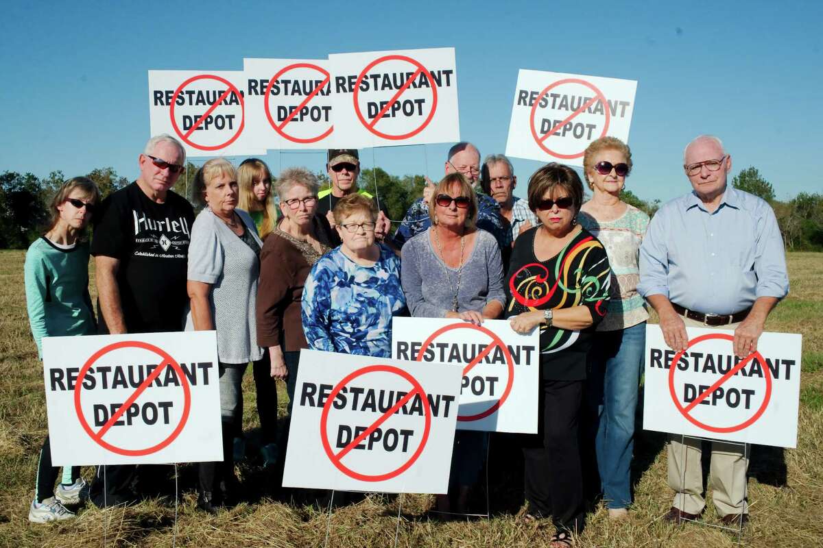 Residents of the Preston Trails subdivision and members of the Preston Trails Homeowners Association stand on the site proposed for a Restaurant Supply Warehouse. Residents have protested the plan, which the company says has been placed on hold.