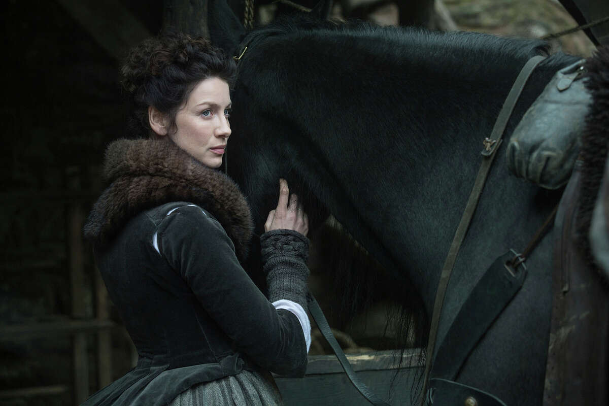 In this image released by Starz, Caitriona Balfe appears in a scene from "Outlander." For a practical gift for that "Outlander," fan, consider replica arm warmers or a cowl inspired by those worn by star Caitriona Balfe. (Ed Miller/Starz via AP) ORG XMIT: NYET601