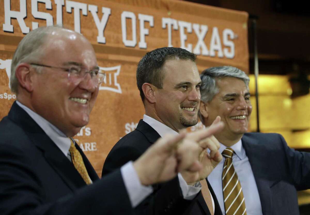 Tom Herman (center) poses with athletic director Mike Perrin (left) and school president Gregory Fenves during a news conference where he was introduce at Texas’ new head football coach on Nov. 27, 2016, in Austin.