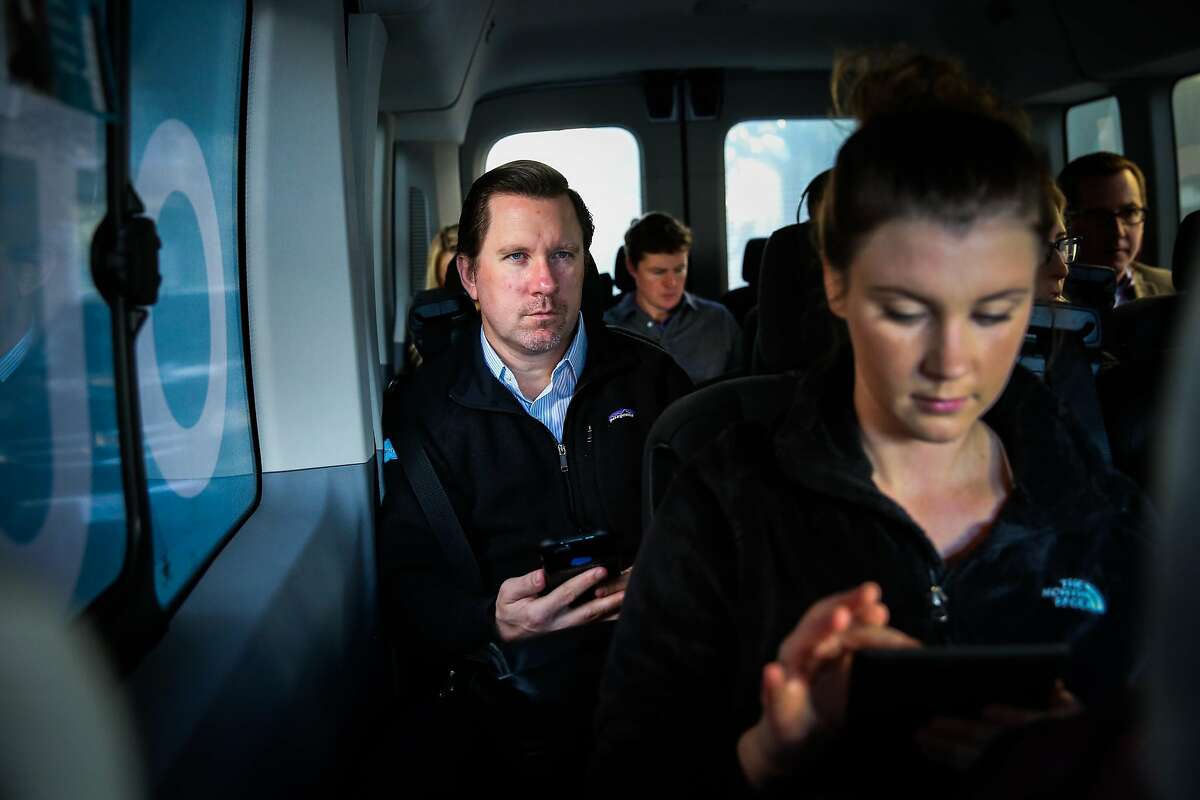 Kevin Eckert (center) and Megan Parker (right) are seen riding in a Chariot commuter-van on their way to work, in San Francisco, California, on Monday, November 28, 2016.