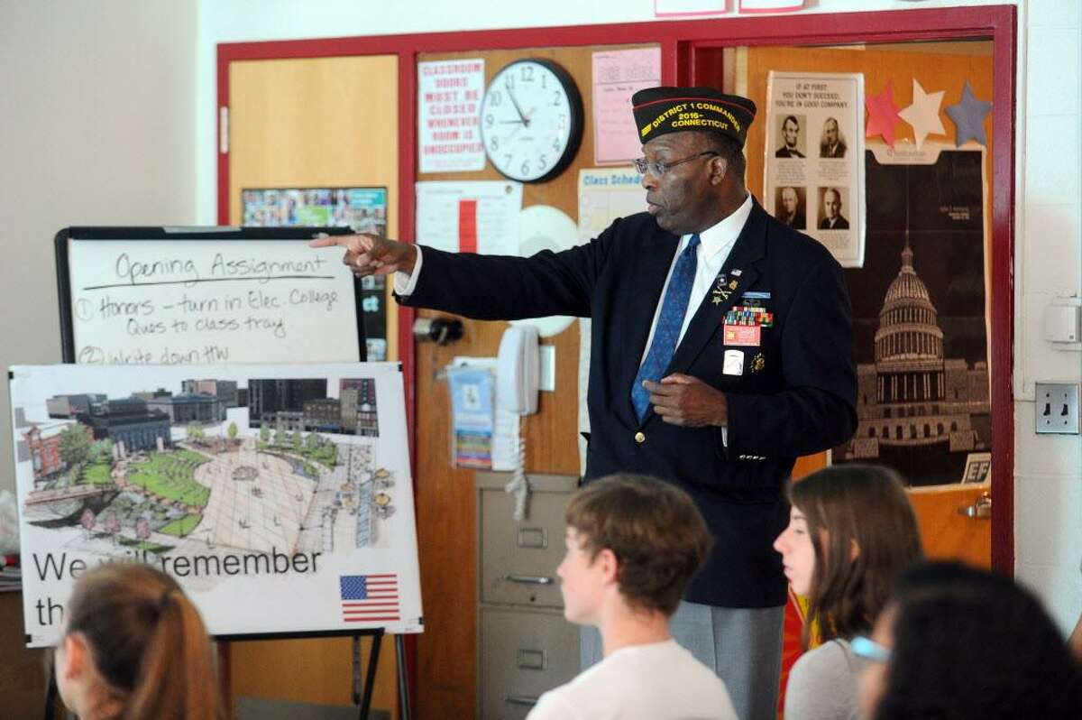 FILE — Archie Elam, a former member of the U.S. Army 18th Airborne Corps 24th Infantry Division, speaks to eighth grade students at Turn of River Middle School, in Stamford, Conn., as part of the school's Veteran's Day program on Thursday, Nov. 10, 2016. Elam served in the Gulf War.