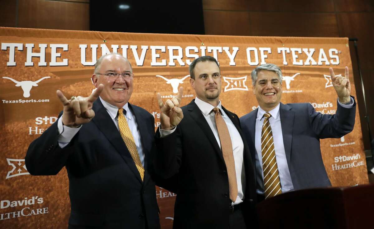 Tom Herman, center, poses with athletic director Mike Perrin, left, and school president Gregory Fenves, right, during a news conference where he was introduced at Texas' new head NCAA college football coach, Sunday, Nov. 27, 2016, in Austin. (AP Photo/Eric Gay)