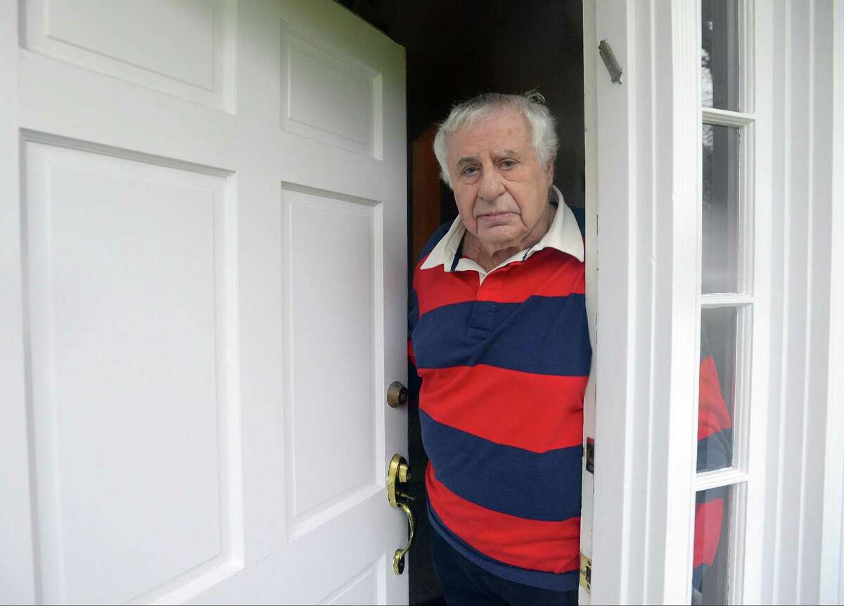 Merlin Alper is photographed in the doorway of his home on Davenport Ridge Lane in Stamford on Nov. 29, 2016. Alper, like many of his neighbors are talking about the big ugly pipe now running across their lawns. Aquarion installed the pipe to bring 4 million gallons of water a day into Stamford from Bridgeport. The Stamford reservoirs are less than half what they should because of the drought.