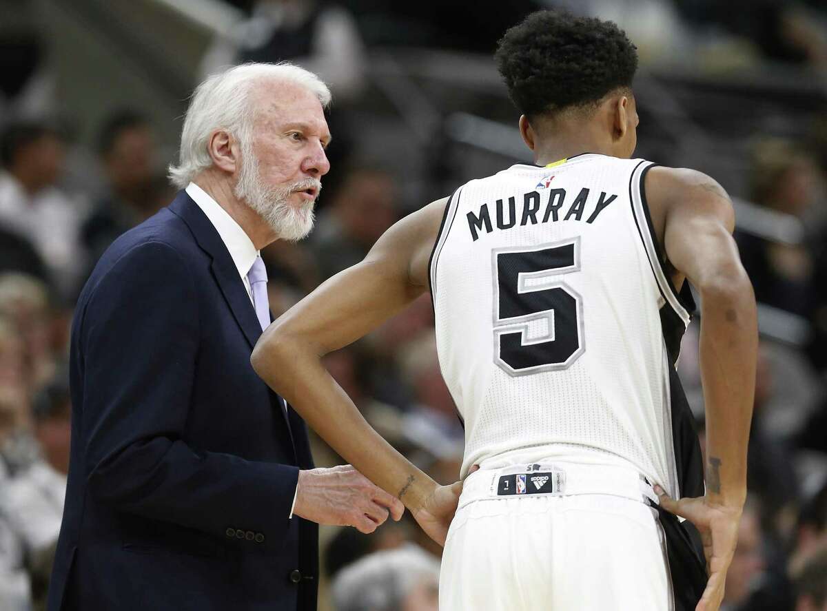 Spurs coach Gregg Popovich talks with Dejounte Murray during their game against the Orlando Magic at the AT&T Center on Nov. 29, 2016.