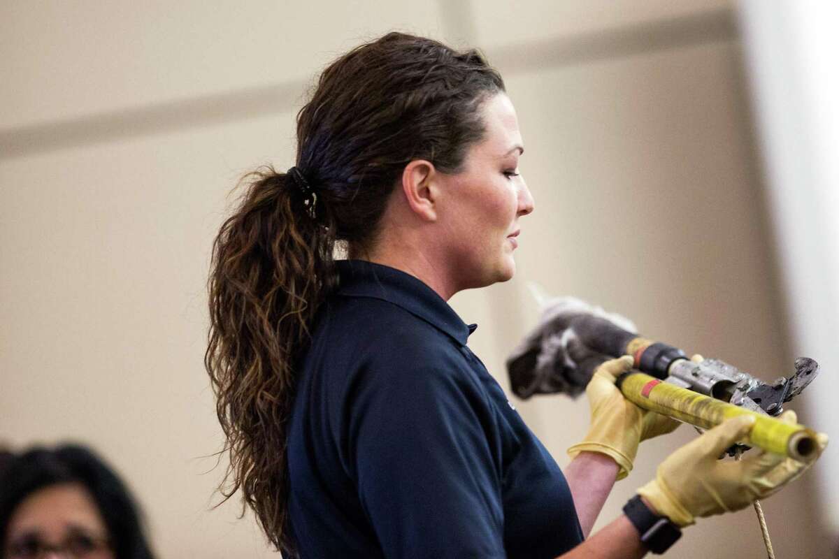 Crime scene investigator Lyndsey Patten examines a tree trimmer submitted as evidence Wednesday in the trial of Michael Scott Quinn. Ray Whitehouse / for the San Antonio Express-News