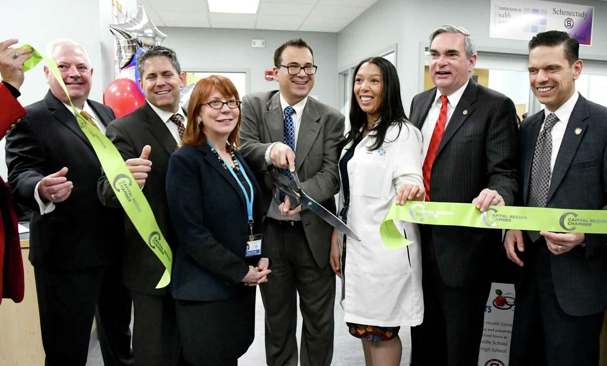 Joe Gambino, CEO of Hometown Health Centers, center, cuts the ribbon to officially open their partnership with the Schenectady School District during a news conference on Wednesday, Nov. 30, 2016, at Schenectady High in Schenectady, N.Y. Joining him, from left, are board member William Faubion, Superintendent Larry Spring, Dr. Melinda Gilmore, nurse practiioner Ashley Gee, Mayor Gary McCarthy and Assemblyman Angelo Santabarbara. (Cindy Schultz / Times Union)
