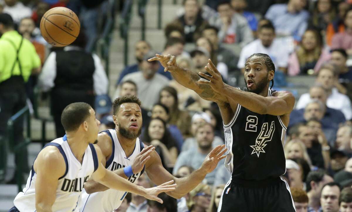 San Antonio Spurs forward Kawhi Leonard (2) passes against Dallas Mavericks defenders Justin Anderson (1) and Seth Curry (30) during the first half of an NBA basketball game in Dallas, Wednesday, Nov. 30, 2016. (AP Photo/LM Otero)