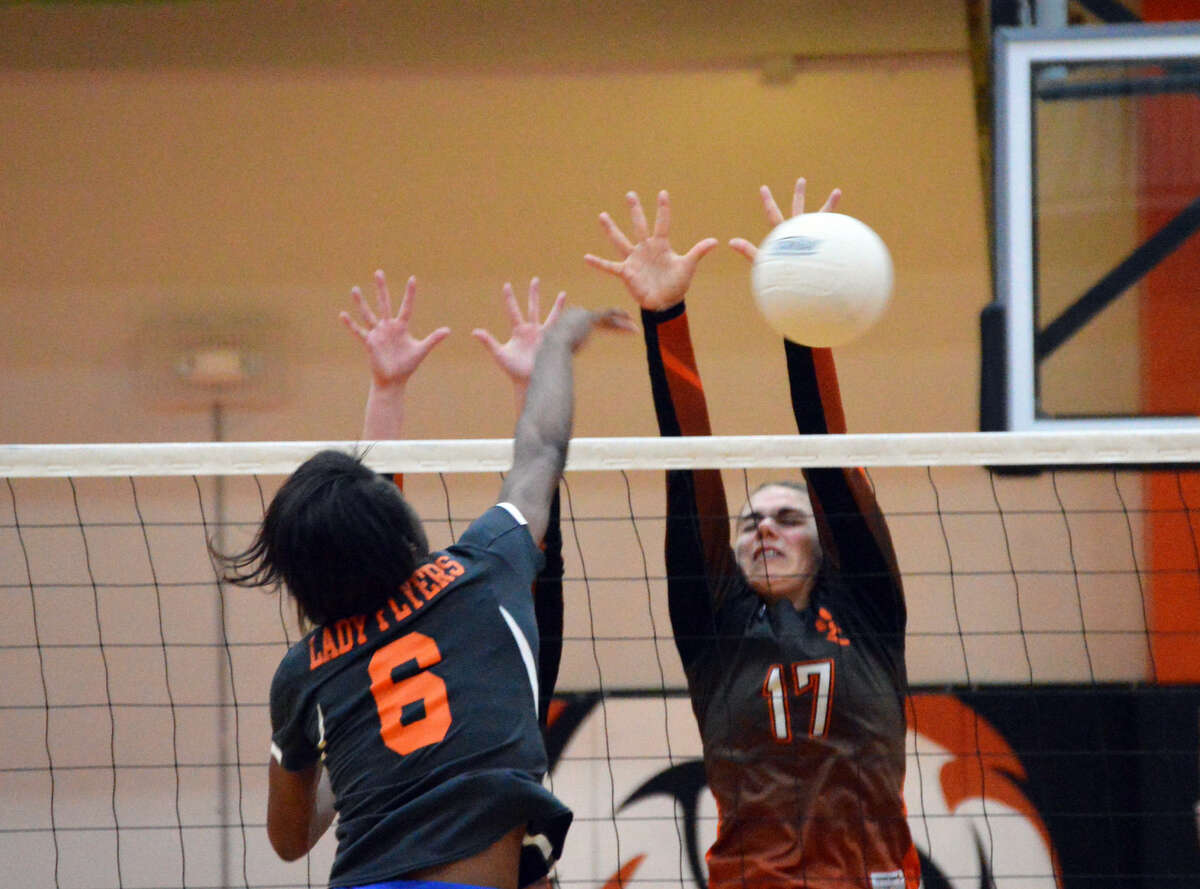 Edwardsville’s Rachel Pranger, right, tries to block a kill attempt by an East St. Louis during the first game Thursday at Lucco-Jackson Gymnasium.