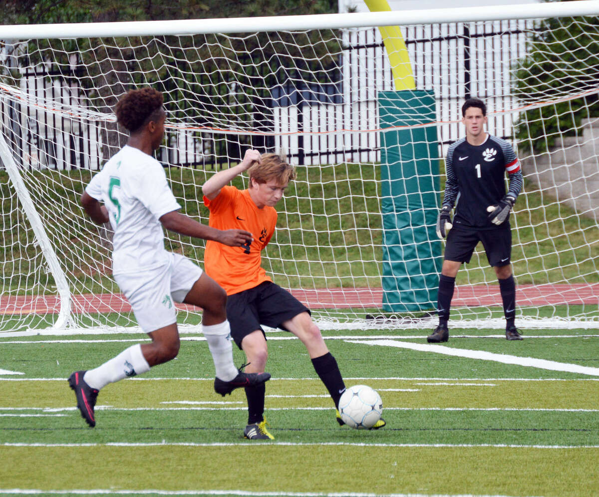 Edwardsville defender Cam Kelehan clears the ball up the field away from a St. Mary’s attacker in second-half action in St. Louis. 