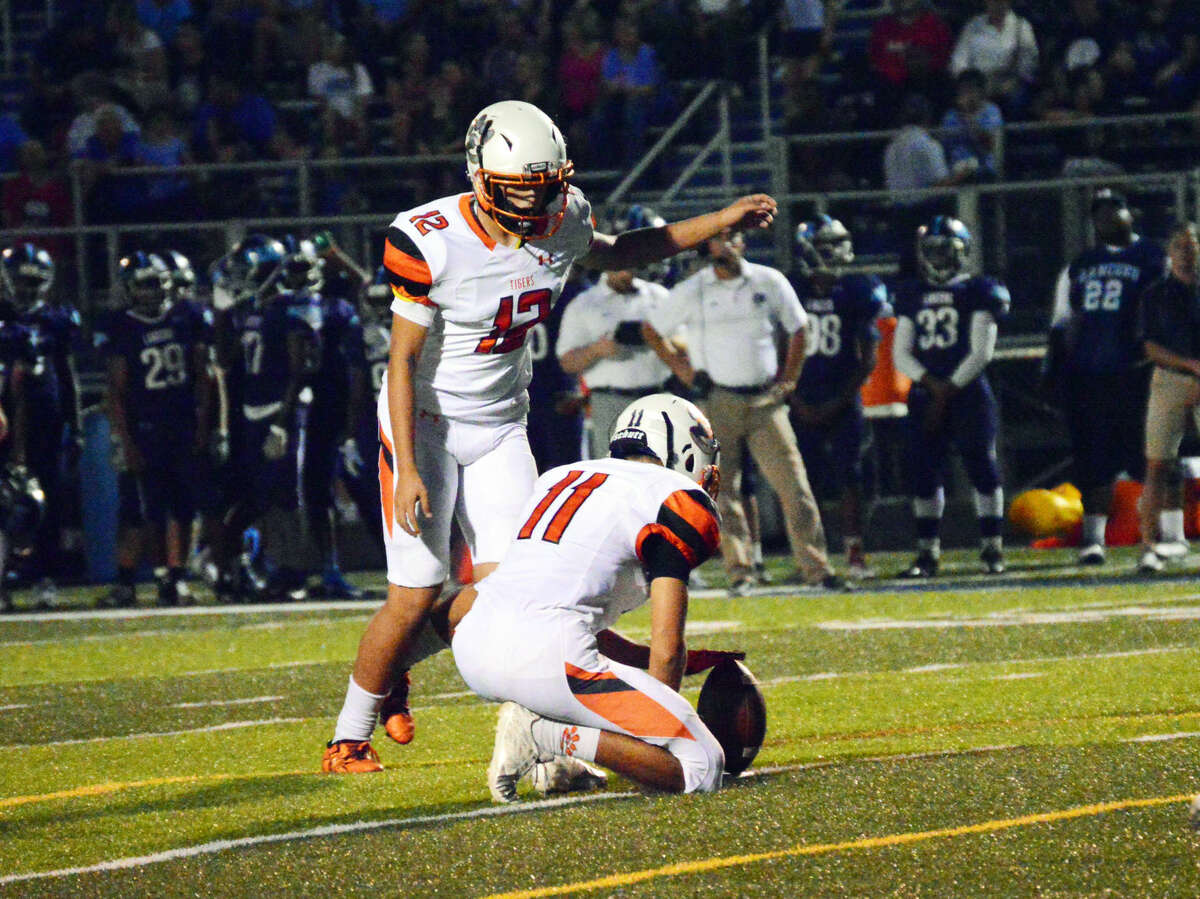 Edwardsville kicker Devin Parker hits one of his seven extra points on Friday with Blake Neville as the holder.