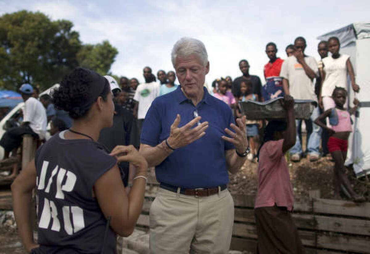 FILE - In this Oct. 6, 2010, file photo, former president and UN special envoy to Haiti, Bill Clinton, center, talks with a member of the J/P NGO as he visits the Petionville Golf Club that is being used as a camp for people who were displaced by the Jan. 12 earthquake in Port-au-Prince, Haiti. Donald Trump is accusing the Clintons of cashing in on Haiti’s deadly 2010 earthquake. The Republican nominee cited State Department emails obtained by the Republican National Committee through a public records request and detailed in an ABC news story. At issue is whether friends of former President Clinton, referred to as “friends of Bill,” or “FOB,” in the emails, received preferential treatment from the State Department in the immediate aftermath of the 7.0-magnitude earthquake. (AP Photo/Ramon Espinosa, File)