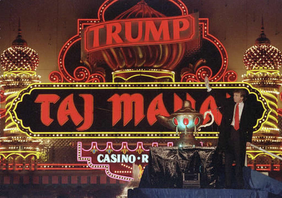 FILE - In this April 5, 1990 file photo, Donald Trump stands next to a genie's lamp as the lights of his Trump Taj Mahal Casino Resort light up during ceremonies to mark its opening in Atlantic City, N.J. Trump opened his Trump Taj Mahal casino 26 years ago, calling it "the eighth wonder of the world." But his friend and fellow billionaire Carl Icahn is closing it Monday morning, making it the fifth casualty of Atlantic City's casino crisis. (AP Photo/Mike Derer, File)