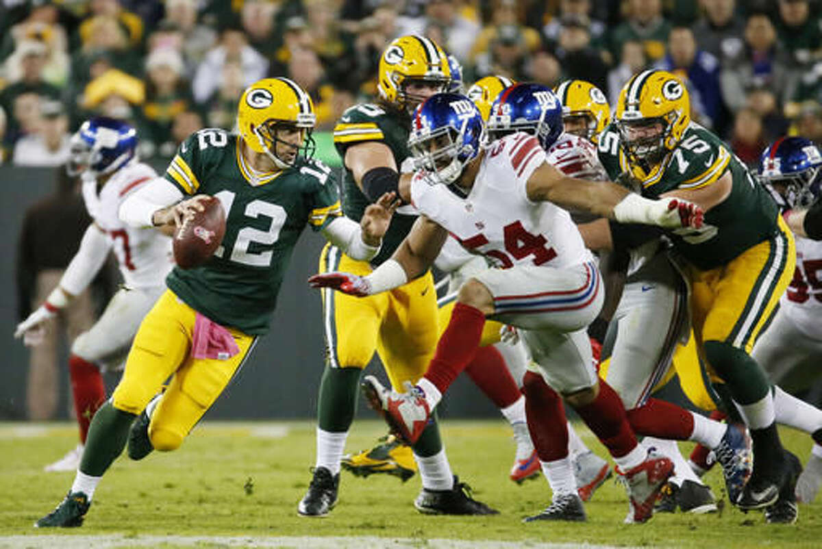 Green Bay Packers' Aaron Rodgers scrambles during the first half of an NFL football game against the New York Giants Sunday, Oct. 9, 2016, in Green Bay, Wis. (AP Photo/Mike Roemer)