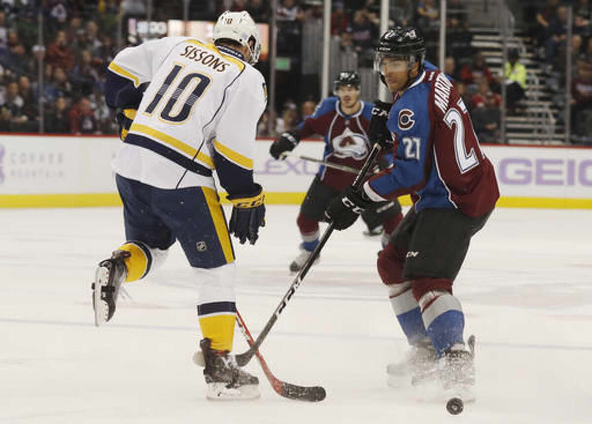 Nashville Predators center Colton Sissons, left, deflects a shot off the stick of Colorado Avalanche left wing Andreas Martinsen, of Norway, during the first period of an NHL hockey game Tuesday, Nov. 1, 2016 in Denver. (AP Photo/David Zalubowski)