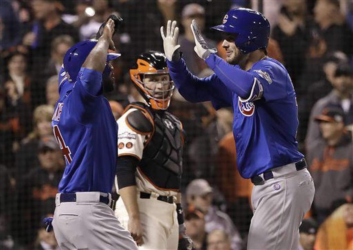 Chicago Cubs' Kris Bryant, right, celebrates with Dexter Fowler after hitting a two-run home run as San Francisco Giants catcher Buster Posey, center, watches during the ninth inning of Game 3 of baseball's National League Division Series in San Francisco, Monday, Oct. 10, 2016. (AP Photo/Marcio Jose Sanchez)